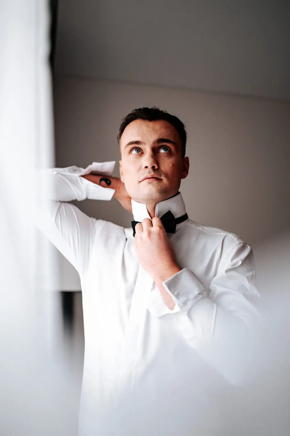 Jaunikis Tomas užsideda varlytę per vestuvių pasiruošimo fotosesiją Hilton viešbutyje