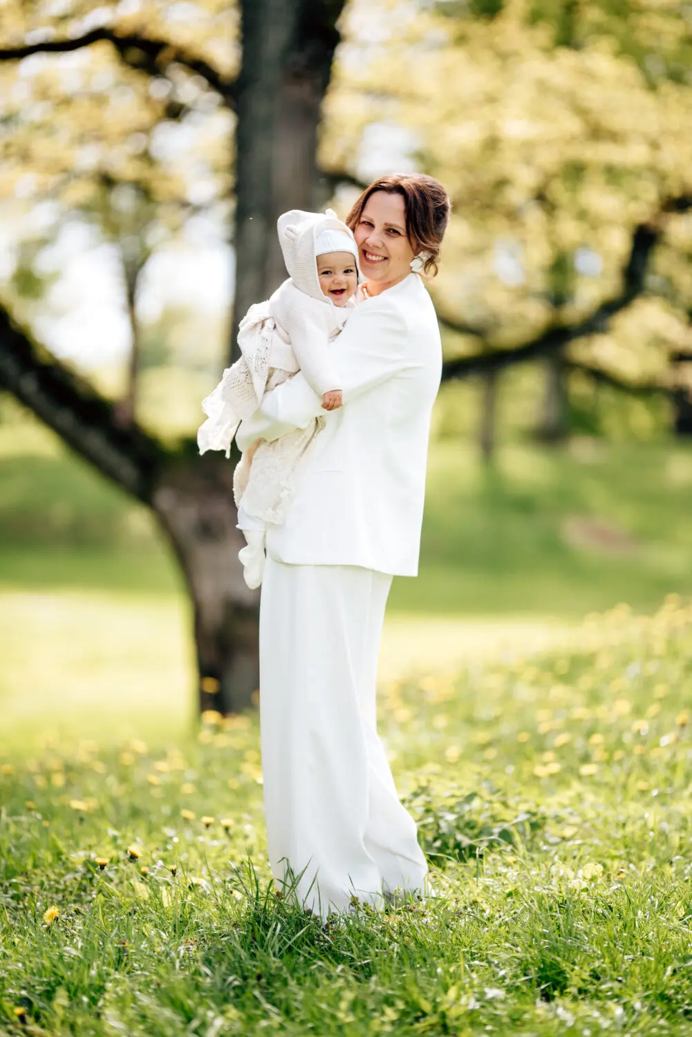 Mama laiko dukrą per krikštynų fotosesiją gamtoje