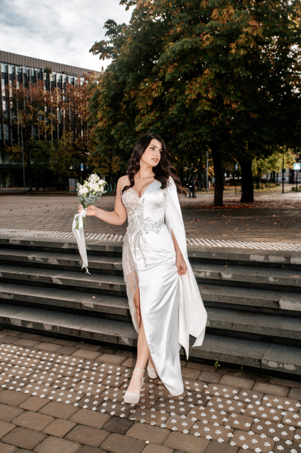 Pora stovi senamiesčio Šv. Ignoto gatvėje, sulietas fonas, fone bažnyčia